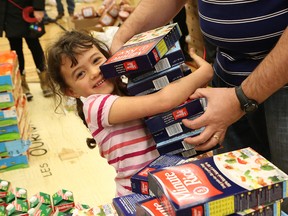 Jillian O'Connor, 6, collects boxes of rice for food baskets at Ecole St-Joseph in Sudbury, Ont. on Saturday December 17, 2016. Club Richelieu Les Patriotes gathered at the school to fill and distribute Christmas food baskets for 158 families in need. John Lappa/Sudbury Star/Postmedia Network