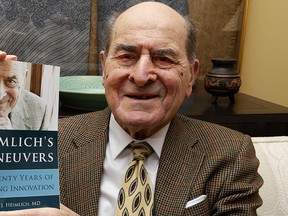 In this Feb. 5, 2014, file photo, Dr. Henry Heimlich holds his memoir prior to being interviewed at his home in Cincinnati.  (AP Photo/Al Behrman, File)