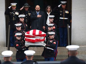 The casket of John Glenn is carried out of the Ohio Statehouse by U.S. Marines during his funeral procession, Saturday, Dec. 17, 2016, in Columbus, Ohio. The famed astronaut died Dec. 8 at age 95. (AP Photo/John Minchillo)
