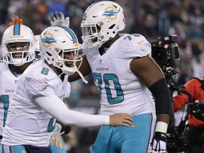 Miami Dolphins quarterback Matt Moore and wide receiver Jarvis Landry celebrate with tackle Ja'Wuan James after Landry scored a touchdown against the New York Jets during the third quarter of an NFL football game, Saturday, Dec. 17, 2016, in East Rutherford, N.J. (AP Photo/Adam Hunger)