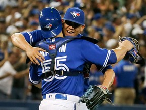 Toronto Blue Jays catcher Russell Martin and pitcher Roberto Osuna hug after a win at the Rogers Centre in Toronto on Aug. 13, 2016. (Veronica Henri/Toronto Sun/Postmedia Network)