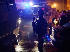 Jordanian security forces stand next to their armoured vehicles at the scene next to Karak Castle, during an ongoing attack, in the central town of Karak, about 140 km south of the capital Amman in Jordan, Sunday, Dec. 18, 2016. (AP Photo/Ben Curtis)