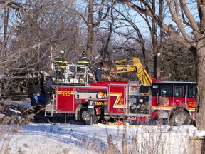 Firefighters from the Six Nations Fire Department in Brantford assist an Ontario Fire Marshall investigator as they sift through a burned out home on Townline Road following a fire Wednesday that has left a man and four of his children dead at the Oneida settlement, south west of London on Thursday. (CRAIG GLOVER, The London Free Press)