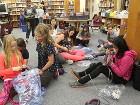 Students in the knitting club at R.G. Sinclair Public School gather in the school library to make tuques for the homeless. (Michael Lea/The Whig-Standard)