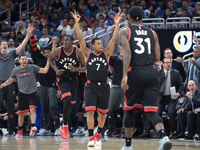Toronto Raptors guard Kyle Lowry and the bench celebrate after forward Terrence Ross hits a three-point basket during an NBA game against the Orlando Magic in Orlando on Dec. 18, 2016. (AP Photo/Phelan M. Ebenhack)