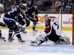 Winnipeg Jets' Drew Stafford (12) can't control the bouncing puck in front of Colorado Avalanche goaltender Calvin Pickard (31) during second period NHL hockey action in Winnipeg, Sunday, December 18, 2016. THE CANADIAN PRESS/Trevor Hagan