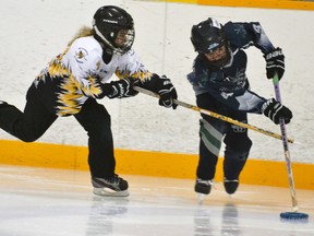 During U9 ringette action against rival St. Marys this past Sunday, Stingers' Torie Czajkowski (left) kept the defensive pressure up as she stick-checked the St. Marys’ defender. The visitors edged the local side, 10-9. GALEN SIMMONS MITCHELL ADVOCATE