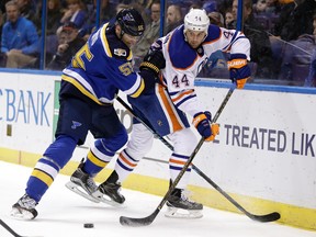 Zack Kassian and Blues defenceman Colton Parayko tangle against the boards during Monday's game in St. Louis. (AP Photo)