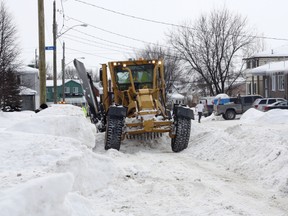 A plow moves snow into the middle of McPhail Street prior to removal in this February 2011 file photo.