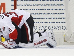 Ottawa Senators goalie Andrew Hammond kneels on the ice after he was hurt during a scrum in the first period of an NHL hockey game against the New York Islanders, Sunday, Dec. 18, 2016, in New York. (AP Photo/Kathy Willens)