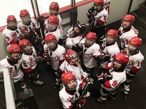 Members of the Toppers Pizza novice Quinte Red Devils wait to hit the ice at the annual Senators Holiday Classic tournament, held recently in Ottawa, where the locals advanced to the quarterfinals. (Submitted photo)