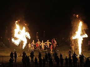 In this Saturday, April 23, 2016 photo, members of the Ku Klux Klan participate in cross and swastika burnings after a "white pride" rally in rural Paulding County near Cedar Town, Ga. (AP Photo/Mike Stewart)