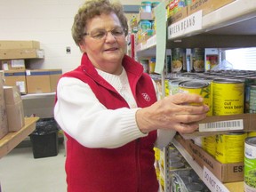 Volunteer Rita Price stocks a shelf Tuesday at the Salvation Army food bank in Sarnia. As of Saturday, the Salvation Army's local kettle campaign had raised $96,000 of its $120,000 goal for this Christmas season. (Paul Morden/Sarnia Observer)