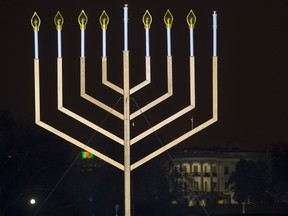 The White House is in the background after the national menorah was lit during a ceremony marking the start of the celebration of Hanukkah, on the Ellipse near the White House in Washington, Tuesday, Dec. 16, 2014. (AP Photo/Cliff Owen)