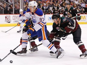 Connor McDavid tries to cut in front of Coyotes defenceman Connor Murphy during the Nov. 25 game in Glendale, Ariz. (AP Photo)