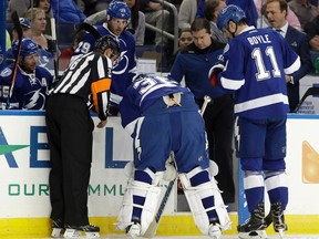 Tampa Bay Lightning goalie Ben Bishop is helped off the ice after making a save during an NHL game on Dec. 20, 2016, in Tampa, Fla. (AP Photo/Chris O'Meara)