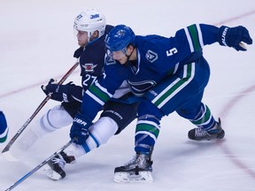 Vancouver Canucks defenceman Luca Sbisa (5) fight for control of the puck with Winnipeg Jets right wing Nikolaj Ehlers (27) during second period NHL action in Vancouver, B.C. Tuesday, Dec. 20, 2016. THE CANADIAN PRESS/Jonathan Hayward