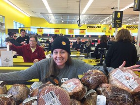Shell employee Jennifer Tomkins poses in this photo, via Twitter, with free hams the company gave away Wednesday at the No Frills grocery store in Sarnia. It was part of Shell's latest "Fuelling Kindness" event. (Handout/Sarnia Observer/Postmedia Network)