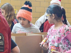 Amelia, left, and Vaishnavi, right, help pack boxes for the Chatham Goodfellows early Dec. 21. They were two of over one hundred people helping to pack and deliver nearly 1,500 boxes around the municipality in time for Christmas.