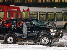 A police officer walks away from the scene of an early morning collision between a OC Transpo bus and a Toyota 4-Runner SUV in January, 2008. The crash proved fatal for three occupants of the SUV. (Mike Carroccetto, Postmedia)