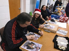 World Wrestling Entertainment hall of famer and wrestling legend Ted (The Million Dollar Man) DiBiase signs autographs at Chinlock Wrestling’s fundraising wrestling show on Saturday at Kingston Gospel Temple while one of its organizers, Constance Carriere-Prill, looks on. DiBiase was on hand to sign autographs and pose for photos at the event, which raised more than $8,000 in support of Youth Diversion Kingston and collected more than 200 toys for Immigrant Services Kingston Area. (Courtesy Chinlock Wrestling)