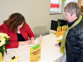 Local author, Mariann Sawyer, attended a book signing for her recently released children's book, Stand-out Sally, at the West Perth Public Library Dec. 17. Here she signs a book for Katherine Mabb, of Mitchell. GALEN SIMMONS MITCHELL ADVOCATE