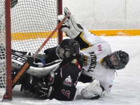 Goderich midget Chad Treble (16) finds himself in the net rather than the puck during WOAA regular season action against Mitchell last Monday, Dec. 19. Meteors' goalie James Vink is also pictured. Goderich trailed 1-0 early but rallied for a 5-1 win over their hosts. ANDY BADER MITCHELL ADVOCATE