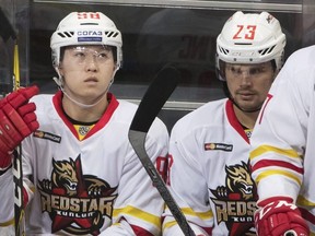 Kunlun Red Star's Rudi Ying (left) and Alexei Ponikarovsky (right) sit on the bench during a Kontinental Hockey League game against Spartak in Moscow on Oct. 1, 2016. (Pavel Golovkin/AP Photo)