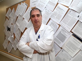 Dr. Adrian Baranchuk in front of some of his research papers he co-wrote at Kingston General Hospital. (Ian MacAlpine/The Whig-Standard)