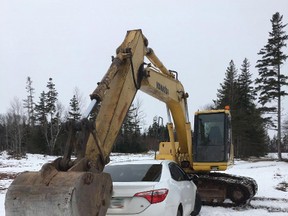 An excavator blocks the path of a car in this handout photo in Brackley, P.E.I. on Thursday, December 22, 2016. (THE CANADIAN PRESS/ HO, RCMP)