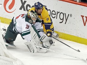 Minnesota Wild goalie Darcy Kuemper stepped away from the net to keep the puck away from Nashville Predators' David Legwand during an NHL game on Feb. 6, 2014. (AP Photo/Jim Mone)