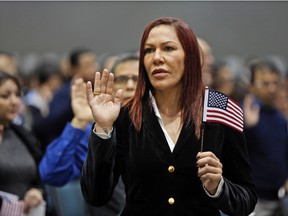 Brazilian UFC fighter Cris 'Cyborg' Justino takes the Oath of Citizenship to become a U.S. citizen during a naturalization ceremony at the Los Angeles Convention Center on Dec. 13, 2016. (AP Photo/Damian Dovarganes)
