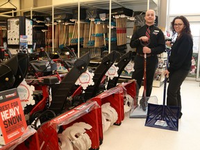 Aaron Winch, left, and Laurie McVittie, of the New Sudbury Canadian Tire, show a selection of snowblowers and shovels available at the store in Sudbury. John Lappa/Sudbury Star/Postmedia Network