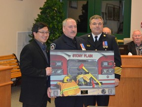 Kimball Scott stands with Stony Plain Mayor William Choy, left, and Fire Chief Trevor Mistal, right, when he was recognized for 20 years of service during a regular council meeting on Dec. 5. - Photo submitted