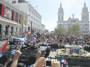 People chant ìI am Fidel!î as the motorcade carrying the ashes of the late Cuban leader Fidel Castro leaves Cespedes Park in Santiago, Cuba, on Dec. 3. After days of national mourning and a tour of his ashes through the countryside, his remains have arrived at the city where they will be laid to rest. (Dario Lopez-Mills/The Associated Press)