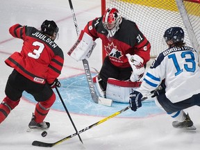 Finland's Henrik Borgstrom (13) moves in on Canada's goaltender Carter Hart as Canada's Noah Juulsen defends during third period pre-tournament action in Montreal on Monday, Dec. 19, 2016. (Graham Hughes/The Canadian Press)