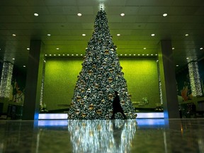 A man walks past the Christmas tree set up inside of Toronto's Commerce Court building, on Wednesday, December 14, 2016. THE CANADIAN PRESS/Graeme Roy