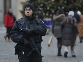 A heavily-armed policeman stands by as visitors walk past near the Brandenburg Gate on December 23, 2016 in Berlin, Germany. (Photo by Sean Gallup/Getty Images)