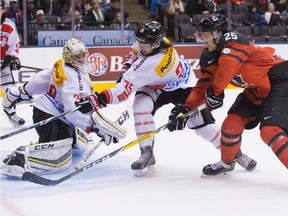 Canada's Nicolas Roy (right) scores his team's game winning overtime goal on Switzerland goaltender Joren van Pottelberghe as his teammate Jonas Siegenthaler covers during world junior exhibition action in Toronto on Friday, Dec. 23, 2016. (Chris Young/The Canadian Press)