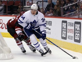 Maple Leafs centre Auston Matthews (34) shields the puck from Coyotes centre Christian Dvorak during first period NHL action in Glendale, Ariz., on Friday, Dec. 23, 2016. (Rick Scuteri/AP Photo)