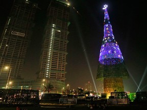 An enormous artificial Christmas tree is seen lit up after its unveiling in Colombo, Sri Lanka, Saturday, Dec. 24, 2016. (AP Photo/Eranga Jayawardena)