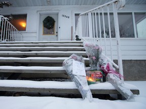 A small memorial sits outside a home at 12248 132 St., in Edmonton on Saturday Dec. 24, 2016. A woman was found dead at a home Dec. 23, 2016. Photo by David Bloom