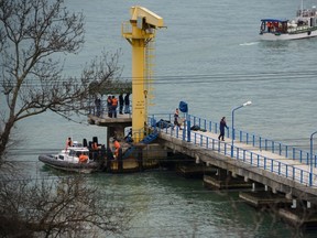 Russian rescue workers collect wreckage of the crashed plane at a pier just outside Sochi, Russia, Sunday, Dec. 25, 2016. (AP Photo/Viktor Klyushin)