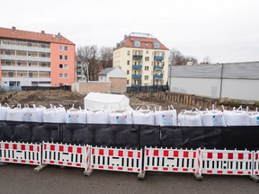 Sand bags and a fence are securing the location of the bomb site next to a construction site in Augsburg, Germany, Sunday Dec. 25, 2016.  (Tobias Hase/dpa via AP)