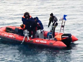 In this frame grab provided by the Russian Emergency Ministry Press Service, ministry employees lift a fragment of a plane outside Sochi, Russia, Monday, Dec. 26, 2016.  (Emergency Situations Ministry Photo via AP)