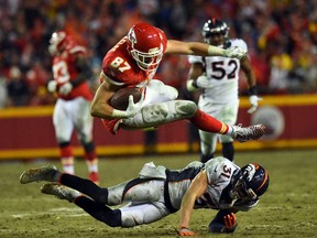 Tight end Travis Kelce #87 of the Kansas City Chiefs leaps over free safety Justin Simmons #31 of the Denver Broncos during the game at Arrowhead Stadium on December 25, 2016 in Kansas City, Missouri. (Photo by Jason Hanna/Getty Images)