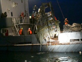 In this late Monday, Dec. 26, 2016 photo provided by the Russian Emergency Ministry Press Service, ministry employees lift a fragment of a plane in the Black Sea, outside Sochi, Russia. (Vladimir Velengurin/Emergency Situations Ministry Photo via AP)