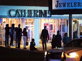 Police officers continue to patrol the area as people linger in the parking lots around Oak Court Mall after the mall was closed due to a disturbance Monday, Dec. 26, 2016, in Memphis, Tenn. (Jim Weber/The Commercial Appeal via AP)