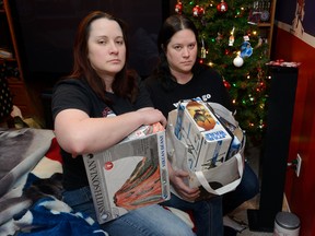 Mel Gillespie, left, and her twin sister Amy Gillespie hold all that's left of the gifts they had accumulated for a Wasaga Beach family that had been burned out of their home before Christmas. The rest of the gifts were stolen from a car on boxing day. (MORRIS LAMONT, The London Free Press)