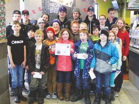 Evergreen School students from the  Ronald's Readers program pose for a photographer with their mentors, members of the Drayton Valley Thunder hockey team.